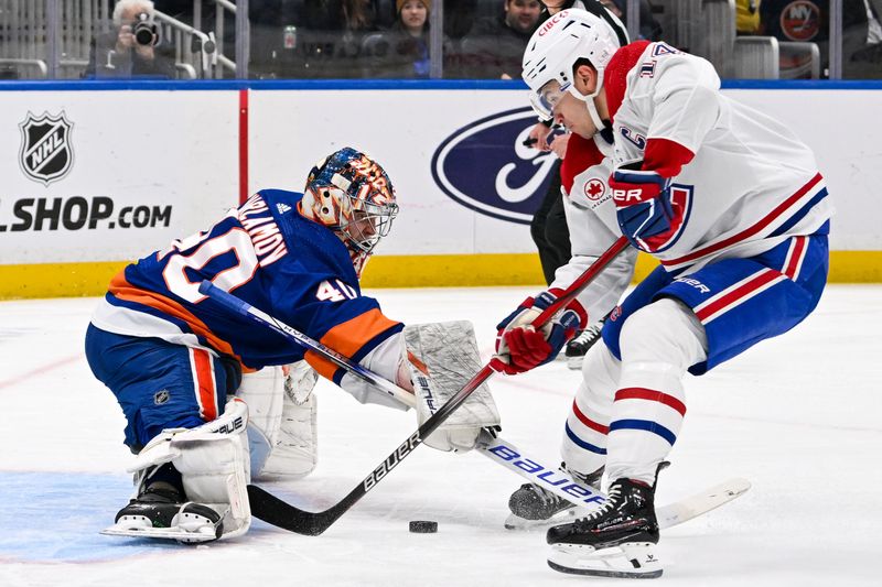 Apr 11, 2024; Elmont, New York, USA; New York Islanders goaltender Semyon Varlamov (40) makes a save on Montreal Canadiens center Nick Suzuki (14) during the first period at UBS Arena. Mandatory Credit: Dennis Schneidler-USA TODAY Sports