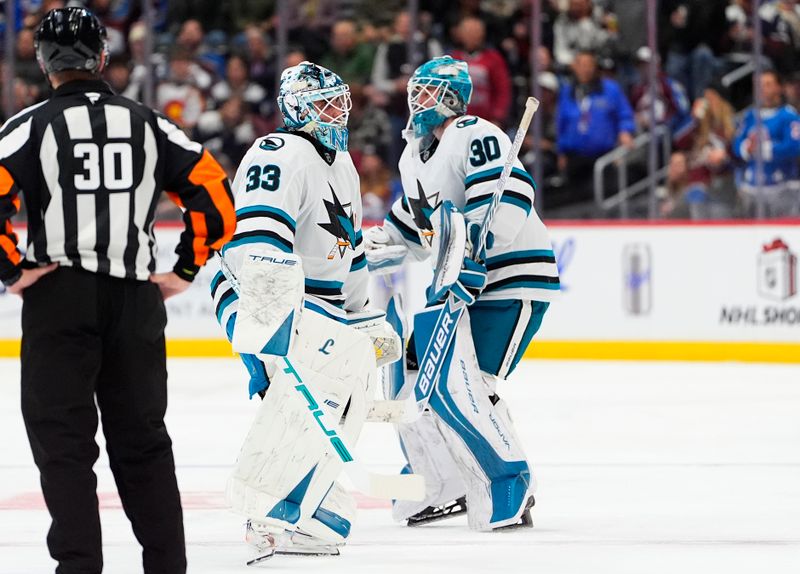 Nov 26, 2025; Denver, Colorado, USA; San Jose Sharks goaltender Yaroslav Askarov (30) leaves the ice for goaltender Alex Nedeljkovic (33) during the second period against the Colorado Avalanche at Ball Arena. Mandatory Credit: Ron Chenoy-Imagn Images
