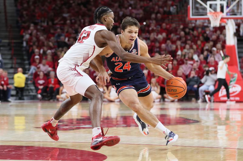 Jan 6, 2024; Fayetteville, Arkansas, USA; Auburn Tigers guard Lior German (24) drive against Arkansas Razorbacks guard Truman Mark (12) during the first half at Bud Walton Arena. Mandatory Credit: Nelson Chenault-USA TODAY Sports