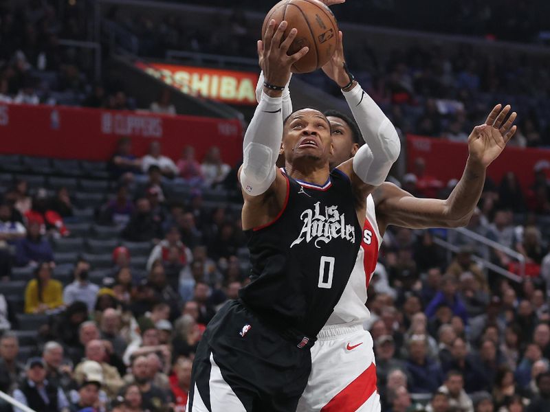 LOS ANGELES, CALIFORNIA - JANUARY 10: Russell Westbrook #0 of the LA Clippers drives past RJ Barrett #9 of the Toronto Raptors during the second half of a game at Crypto.com Arena on January 10, 2024 in Los Angeles, California.  NOTE TO USER: User expressly acknowledges and agrees that, by downloading and or using this photograph, User is consenting to the terms and conditions of the Getty Images License Agreement. (Photo by Sean M. Haffey/Getty Images)