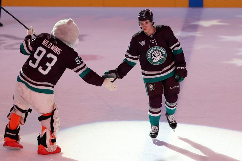 Mar 6, 2024; Anaheim, California, USA;  Anaheim Ducks defenseman Olen Zellweger (51) celebrates a victory with the Wild wing (93) after defeating the Ottawa Senators 2-1 at Honda Center. Mandatory Credit: Kiyoshi Mio-USA TODAY Sports