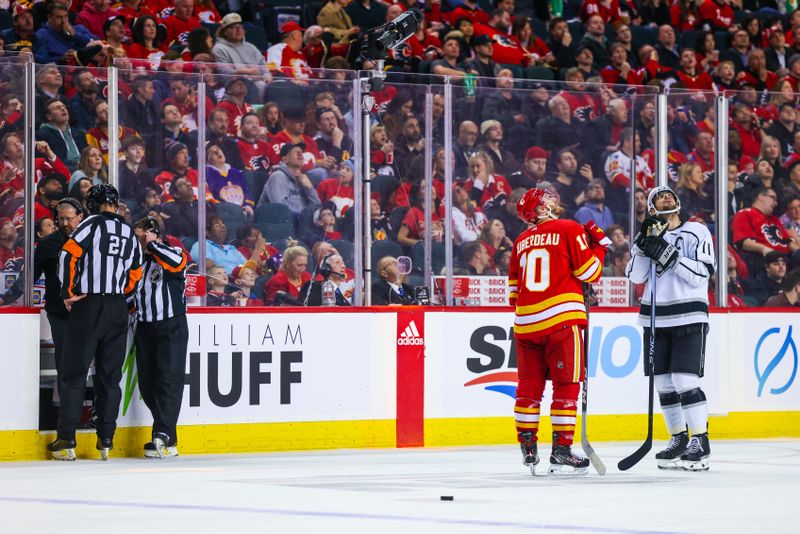 Mar 28, 2023; Calgary, Alberta, CAN; Calgary Flames center Jonathan Huberdeau (10) and Los Angeles Kings center Anze Kopitar (11) waiting as a play under the video review during the second period at Scotiabank Saddledome. Mandatory Credit: Sergei Belski-USA TODAY Sports