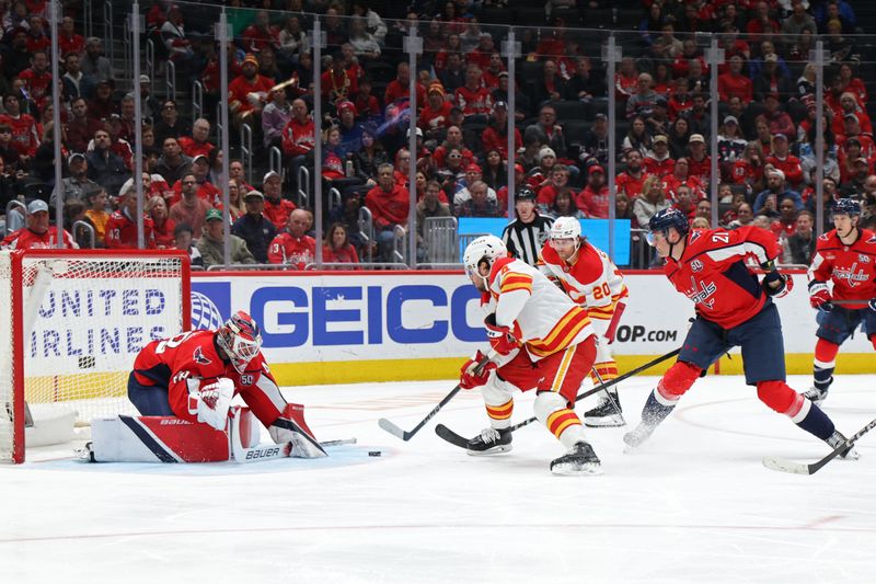 Feb 25, 2025; Washington, District of Columbia, USA; Washington Capitals goaltender Logan Thompson (48) makes a save on Calgary Flames defenseman Rasmus Andersson (4) as Capitals center Aliaksei Protas (21) defends in the second period at Capital One Arena. Mandatory Credit: Geoff Burke-Imagn Images