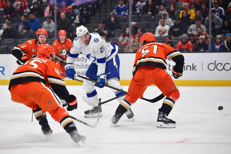 Dec 31, 2025; Anaheim, California, USA; Anaheim Ducks right wing Beckett Sennecke (45) and defenseman Olen Zellweger (51) play for the puck against Tampa Bay Lightning center Brayden Point (21) during the first period at Honda Center. Mandatory Credit: Gary A. Vasquez-Imagn Images