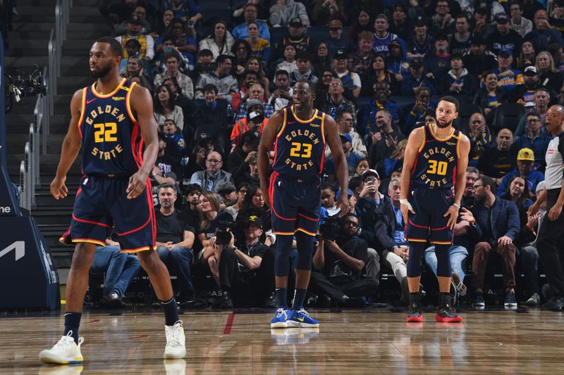 SAN FRANCISCO, CA - JANUARY 5:  Andrew Wiggins #22, Draymond Green #23 and Stephen Curry #30 of the Golden State Warriors looks on during the game against the Sacramento Kings on January 5, 2025 at Chase Center in San Francisco, California. NOTE TO USER: User expressly acknowledges and agrees that, by downloading and or using this photograph, user is consenting to the terms and conditions of Getty Images License Agreement. Mandatory Copyright Notice: Copyright 2025 NBAE (Photo by Noah Graham/NBAE via Getty Images)