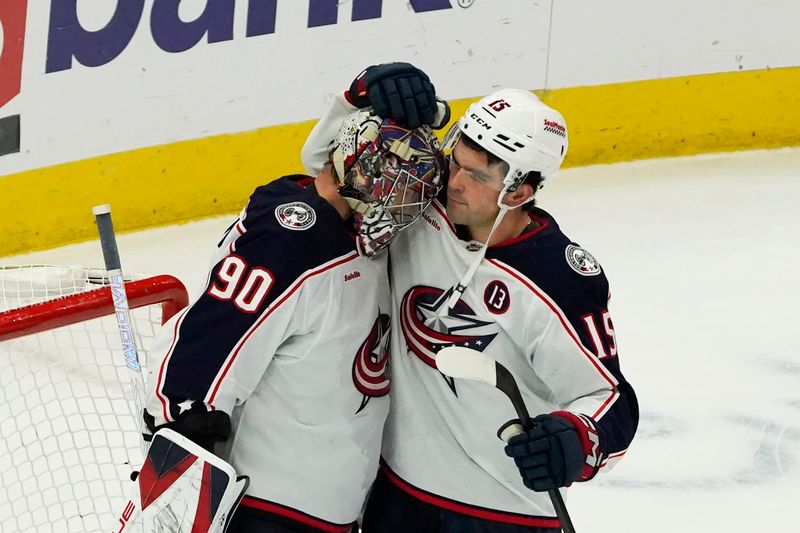 Dec 1, 2024; Chicago, Illinois, USA; Columbus Blue Jackets goaltender Elvis Merzlikins (90) and defenseman Dante Fabbro (15) celebrate their win against the Chicago Blackhawks at United Center. Mandatory Credit: David Banks-Imagn Images