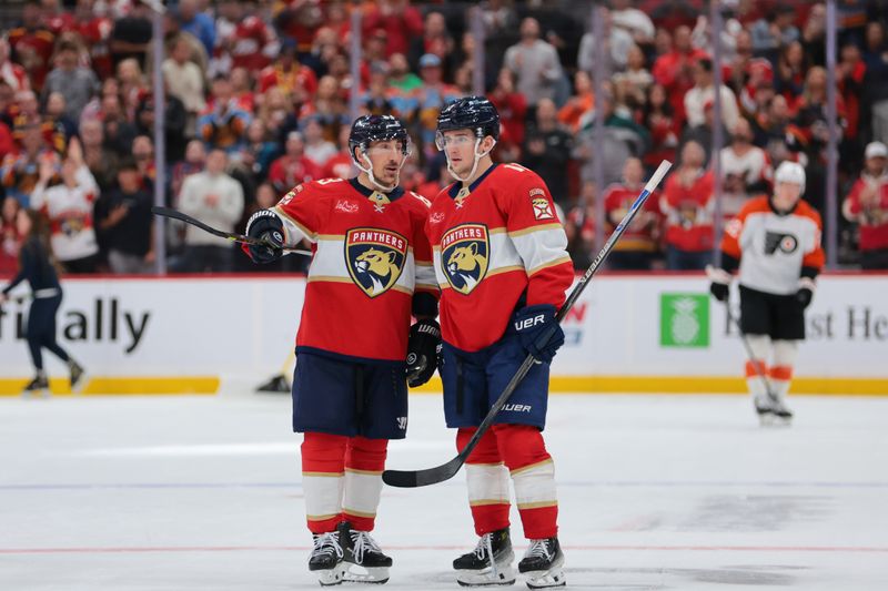 Nov 26, 2025; Sunrise, Florida, USA; Florida Panthers left wing Brad Marchand (63) speaks to right wing Mackie Samoskevich (11) against the Philadelphia Flyers during the second period at Amerant Bank Arena. Mandatory Credit: Sam Navarro-Imagn Images