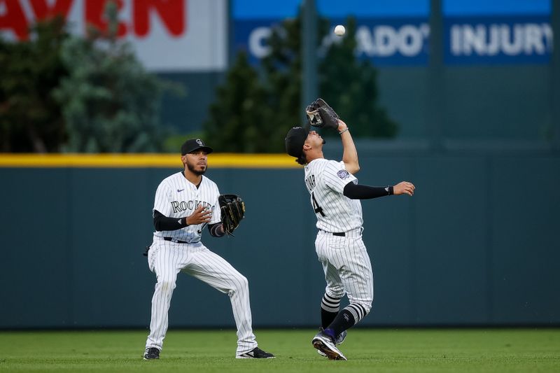 May 26, 2023; Denver, Colorado, USA; Colorado Rockies shortstop Ezequiel Tovar (14) makes a catch ahead of center fielder Harold Castro (30) in the fifth inning against the New York Mets at Coors Field. Mandatory Credit: Isaiah J. Downing-USA TODAY Sports