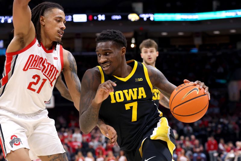 Jan 27, 2025; Columbus, Ohio, USA; Iowa Hawkeyes forward Seydou Traore (7) drives to the basket as Ohio State Buckeyes forward Devin Royal (21) defends during the first half at Value City Arena. Mandatory Credit: Joseph Maiorana-Imagn Images