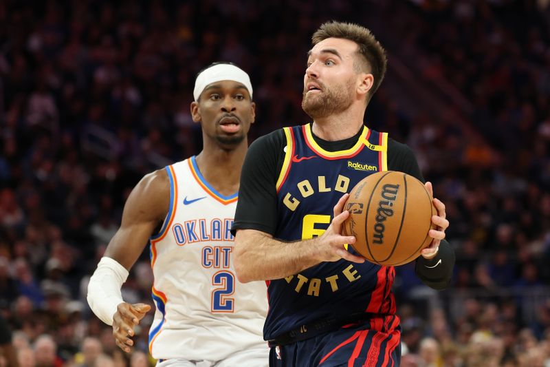 SAN FRANCISCO, CALIFORNIA - NOVEMBER 27: Pat Spencer #61 of the Golden State Warriors drives to the basket against Shai Gilgeous-Alexander #2 of the Oklahoma City Thunder during the second half at Chase Center on November 27, 2024 in San Francisco, California. NOTE TO USER: User expressly acknowledges and agrees that, by downloading and or using this photograph, User is consenting to the terms and conditions of the Getty Images License Agreement (Photo by Ezra Shaw/Getty Images)