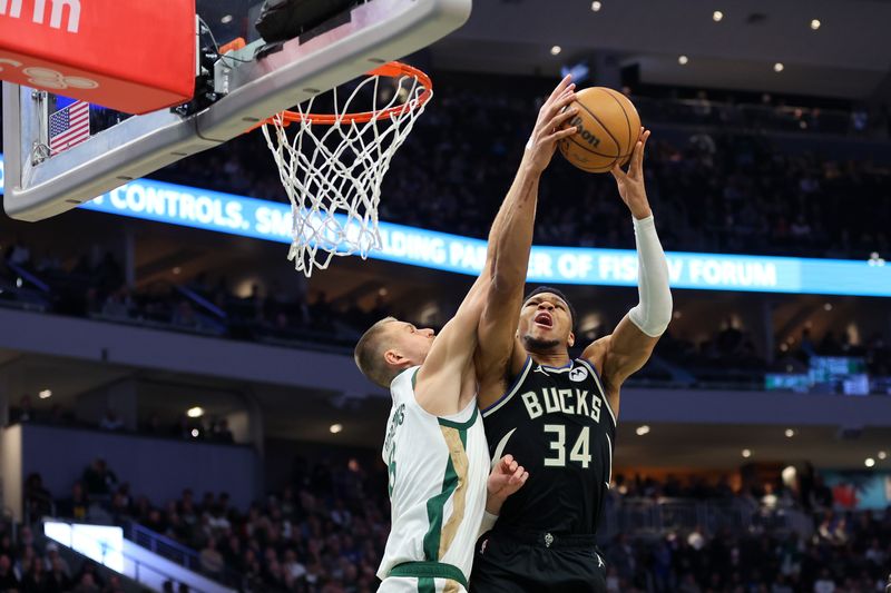 MILWAUKEE, WISCONSIN - JANUARY 11: Giannis Antetokounmpo #34 of the Milwaukee Bucks drives to the basket against Kristaps Porzingis #8 of the Boston Celtics during the first half of a game at Fiserv Forum on January 11, 2024 in Milwaukee, Wisconsin. NOTE TO USER: User expressly acknowledges and agrees that, by downloading and or using this photograph, User is consenting to the terms and conditions of the Getty Images License Agreement. (Photo by Stacy Revere/Getty Images)