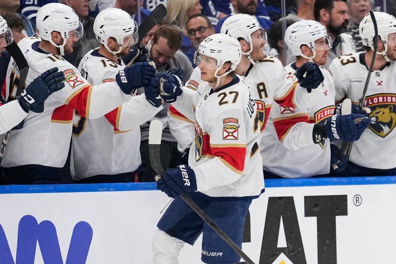 May 18, 2025; Toronto, Ontario, CAN; Florida Panthers forward Eetu Luostarinen (27) is congratulated by teammates after scoring against the Toronto Maple Leafs during the third period of game seven of the second round of the 2025 Stanley Cup Playoffs at Scotiabank Arena. Mandatory Credit: John E. Sokolowski-Imagn Images