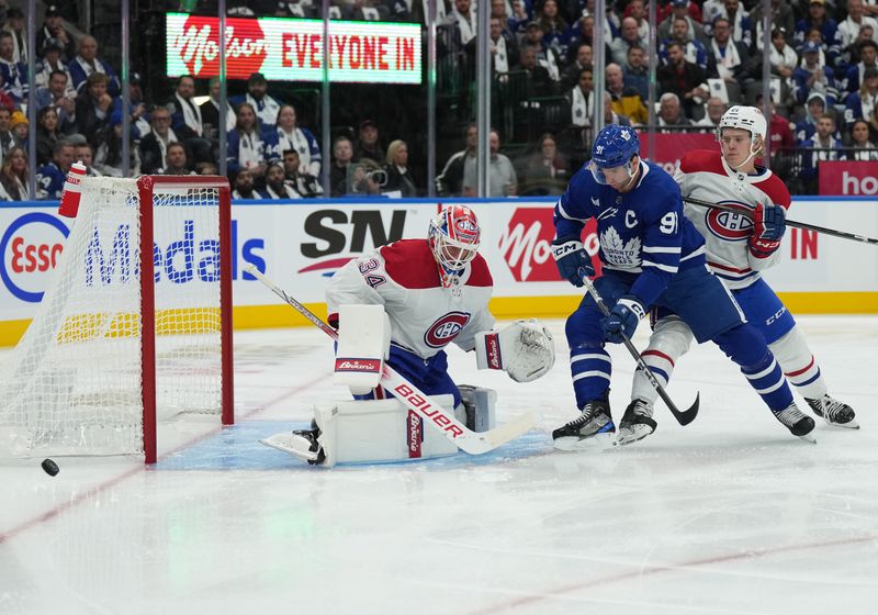 Oct 11, 2023; Toronto, Ontario, CAN; Toronto Maple Leafs center John Tavares (91) battles for the puck with Montreal Canadiens defenseman Kaiden Guhle (21) in front of Montreal Canadiens goaltender Jake Allen (34) during the first period at Scotiabank Arena. Mandatory Credit: Nick Turchiaro-USA TODAY Sports