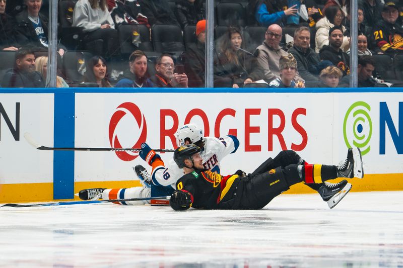 Jan 19, 2026; Vancouver, British Columbia, CAN; New York Islanders defenseman Matthew Schaefer (48) and Vancouver Canucks forward Elias Pettersson (40) lie on the ice after colliding in the first period at Rogers Arena. Mandatory Credit: Bob Frid-Imagn Images