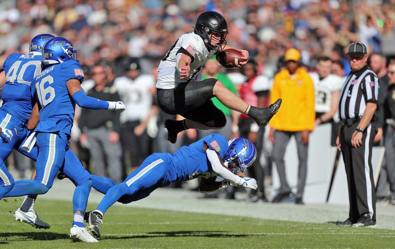 Nov 4, 2023; Denver, Colorado, USA; Army Black Knights quarterback Bryson Daily (13) hurdles a defender during the first half against the Air Force Falcons at Empower Field at Mile High. Mandatory Credit: Danny Wild-USA TODAY Sports