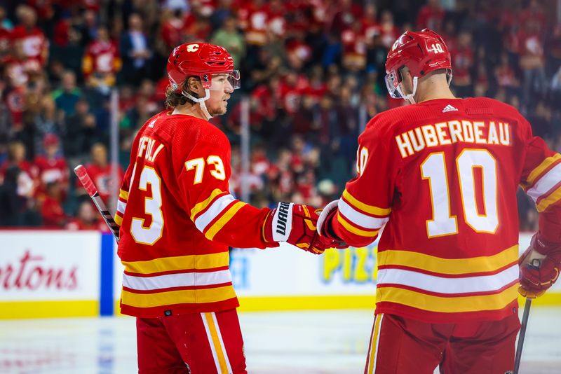 Oct 13, 2022; Calgary, Alberta, CAN; Calgary Flames right wing Tyler Toffoli (73) celebrates his goal with center Jonathan Huberdeau (10) against the Colorado Avalanche during the third period at Scotiabank Saddledome. Mandatory Credit: Sergei Belski-USA TODAY Sports