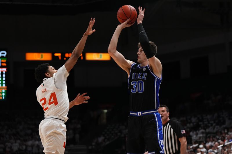 Feb 6, 2023; Coral Gables, Florida, USA; Duke Blue Devils center Kyle Filipowski (30) attempts a three point shot over Miami Hurricanes guard Nijel Pack (24) during the first half at Watsco Center. Mandatory Credit: Jasen Vinlove-USA TODAY Sports