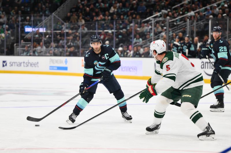 Mar 4, 2025; Seattle, Washington, USA; Seattle Kraken right wing Jordan Eberle (7) plays the puck while defended by Minnesota Wild defenseman Jake Middleton (5) during the third period at Climate Pledge Arena. Mandatory Credit: Steven Bisig-Imagn Images