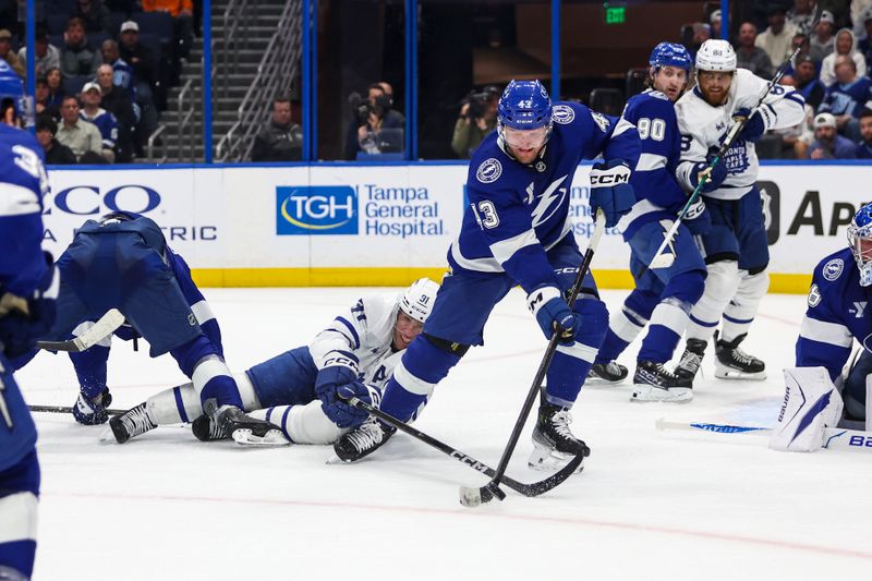 Feb 25, 2026; Tampa, Florida, USA; Toronto Maple Leafs forward John Tavares (91) dives for the puck against Tampa Bay Lightning defenseman Darren Raddysh (43) during the second period at Benchmark International Arena. Mandatory Credit: Morgan Tencza-Imagn Images