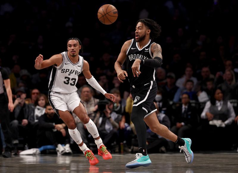 NEW YORK, NEW YORK - FEBRUARY 10: Trendon Watford #9 of the Brooklyn Nets passes the ball as Tre Jones #33 of the San Antonio Spurs defends in the first half at Barclays Center on February 10, 2024 in the Brooklyn borough of New York City. NOTE TO USER: User expressly acknowledges and agrees that, by downloading and or using this photograph, User is consenting to the terms and conditions of the Getty Images License Agreement. (Photo by Elsa/Getty Images)