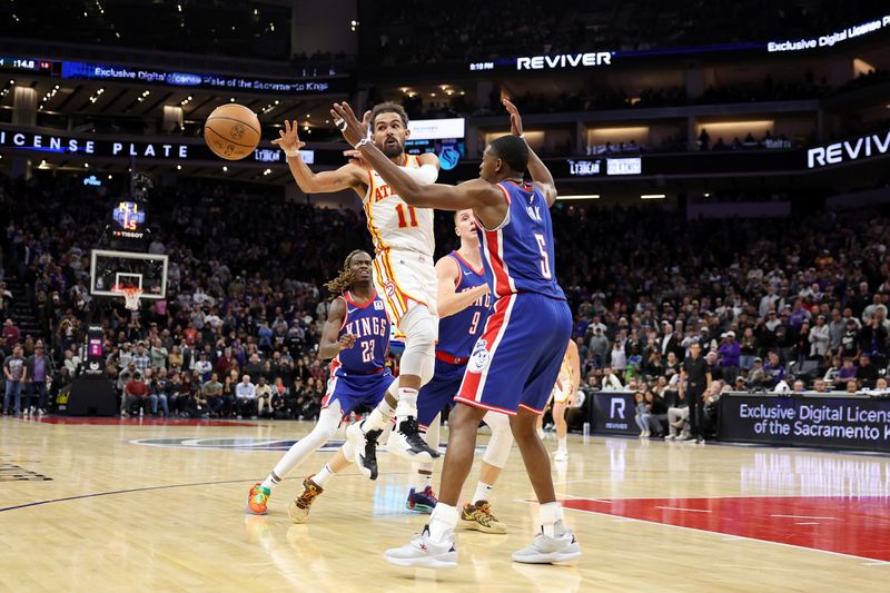 SACRAMENTO, CALIFORNIA - NOVEMBER 18: Trae Young #11 of the Atlanta Hawks passes the ball around De'Aaron Fox #5 of the Sacramento Kings at Golden 1 Center on November 18, 2024 in Sacramento, California. NOTE TO USER: User expressly acknowledges and agrees that, by downloading and/or using this photograph, user is consenting to the terms and conditions of the Getty Images License Agreement.   (Photo by Ezra Shaw/Getty Images)