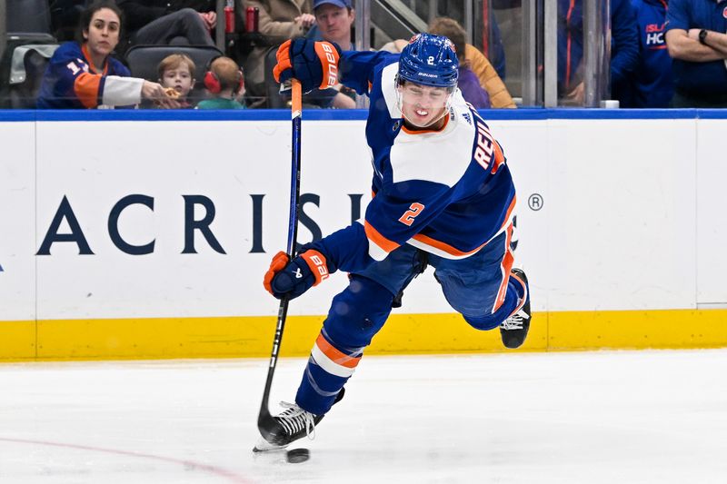 Mar 24, 2024; Elmont, New York, USA;  New York Islanders defenseman Mike Reilly (2) attempts a shot against the New Jersey Devilsa during the second period at UBS Arena. Mandatory Credit: Dennis Schneidler-USA TODAY Sports