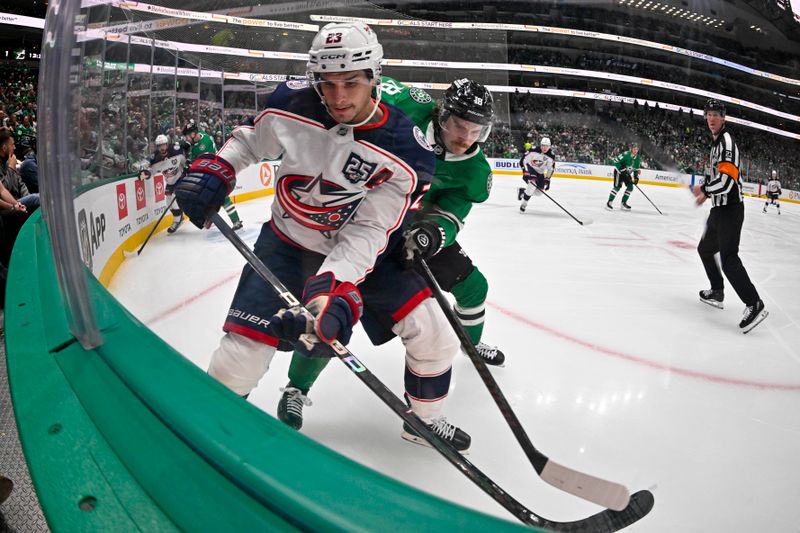 Oct 21, 2025; Dallas, Texas, USA; Dallas Stars center Sam Steel (18) and Columbus Blue Jackets center Sean Monahan (23) battle for control of the puck during the third period at the American Airlines Center. Mandatory Credit: Jerome Miron-Imagn Images