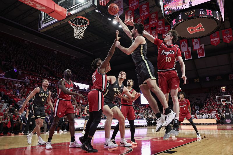 Jan 28, 2024; Piscataway, New Jersey, USA; Purdue Boilermakers center Zach Edey (15) shoots the ball against Rutgers Scarlet Knights guard Gavin Griffiths (10) and forward Antwone Woolfolk (13) during the first half at Jersey Mike's Arena. Mandatory Credit: Vincent Carchietta-USA TODAY Sports