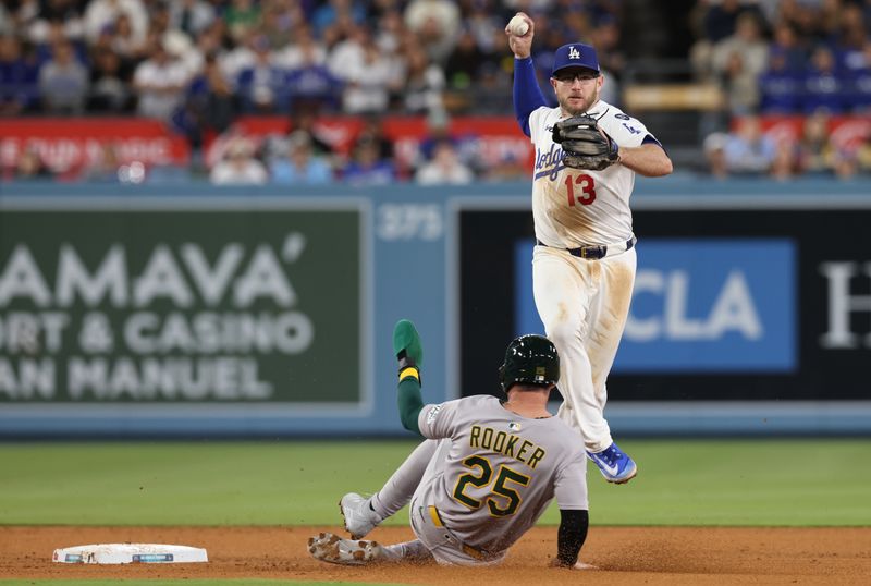 May 14, 2025; Los Angeles, California, USA;  Athletics outfielder Brent Rooker (25) breaks up a double play attempt by Los Angeles Dodgers third baseman Max Muncy (13) during the sixth inning at Dodger Stadium. Mandatory Credit: Jason Parkhurst-Imagn Images