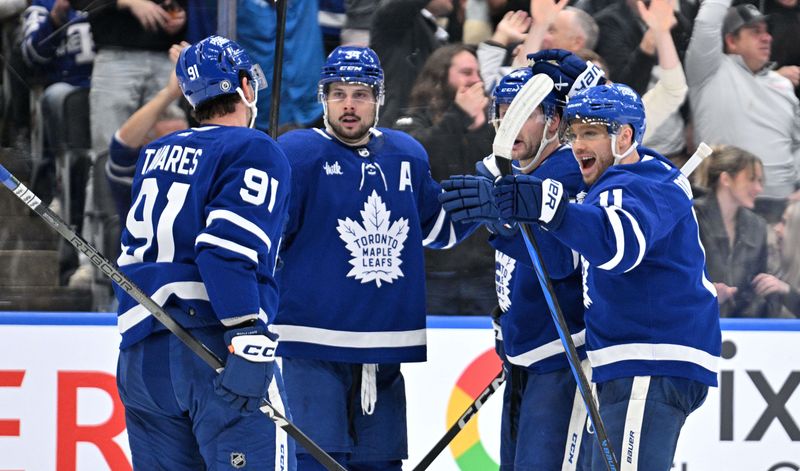 Apr 11, 2024; Toronto, Ontario, CAN; Toronto Maple Leafs forward John Tavares (91) celebrates with forwards Max Domi (11) and Auston Matthews (34) and defenseman Morgan Rielly (44) after scoring against the New Jersey Devils in the third period at Scotiabank Arena. Mandatory Credit: Dan Hamilton-USA TODAY Sports