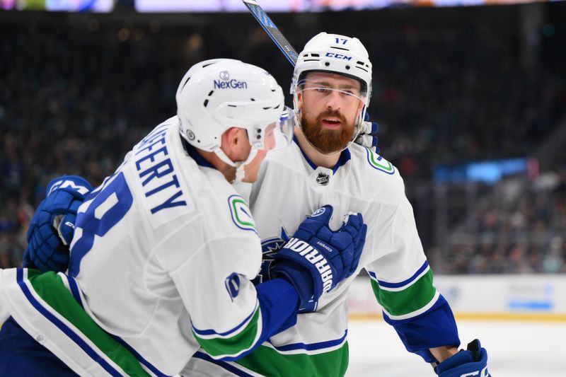 Nov 24, 2023; Seattle, Washington, USA; Vancouver Canucks defenseman Filip Hronek (17) and center Sam Lafferty (18) celebrate after Hronek scored a goal against the Seattle Kraken during the third period at Climate Pledge Arena. Mandatory Credit: Steven Bisig-USA TODAY Sports