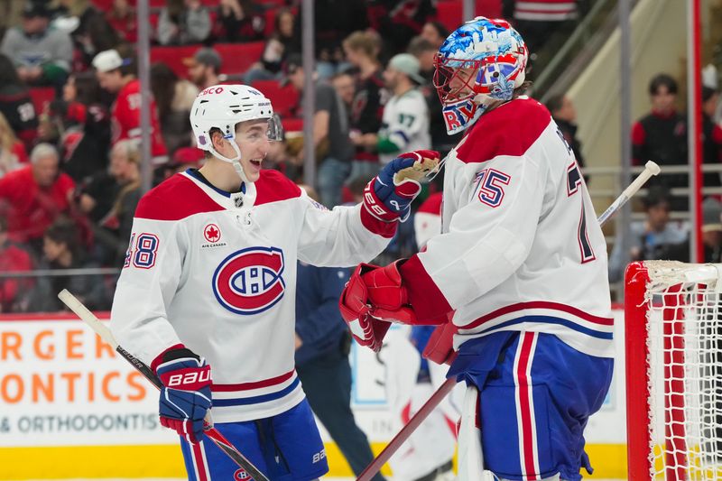 Jan 1, 2026; Raleigh, North Carolina, USA;  Montréal Canadiens goaltender Jakub Dobes (75) and Montréal Canadiens defenseman Lane Hutson (48) celebrates their victory against the Carolina Hurricanes at Lenovo Center. Mandatory Credit: James Guillory-Imagn Images
