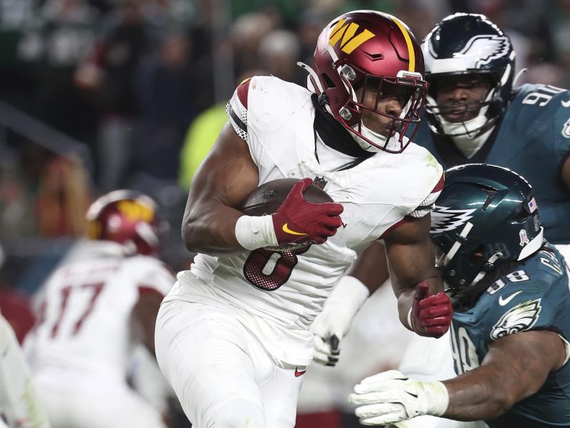 Washington Commanders running back Brian Robinson Jr. (8) runs with the ball during an NFL football game against the Philadelphia Eagles, Thursday, Nov. 14, 2024, in Philadelphia, PA. (AP Photo/Peter Joneleit)