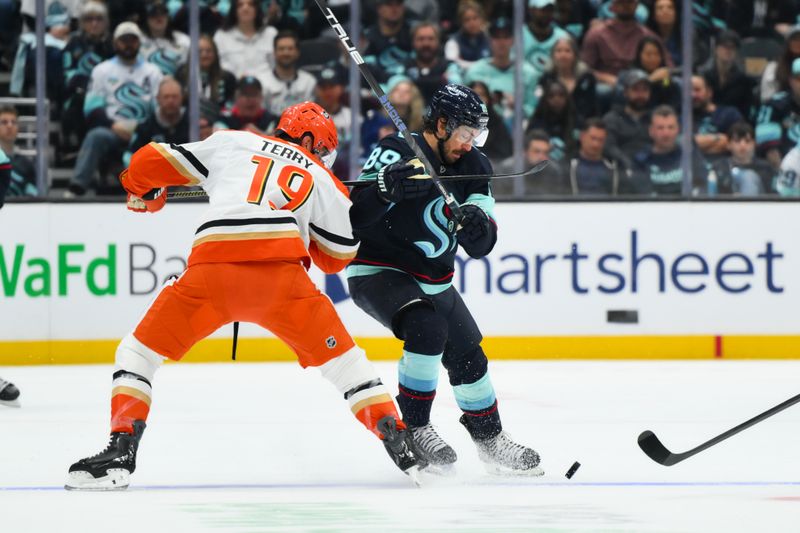 Oct 9, 2025; Seattle, Washington, USA; Seattle Kraken center Frederick Gaudreau (89) plays the puck while defended by Anaheim Ducks right wing Troy Terry (19) during the second period at Climate Pledge Arena. Mandatory Credit: Steven Bisig-Imagn Images