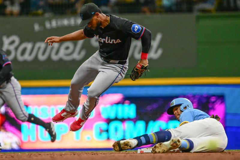 Jul 26, 2024; Milwaukee, Wisconsin, USA; Miami Marlins second baseman Otto Lopez (61) jumps away after tagging out Milwaukee Brewers center fielder Blake Perkins (16) trying to stretch a single into a double in the fifth inning at American Family Field. Mandatory Credit: Benny Sieu-USA TODAY Sports