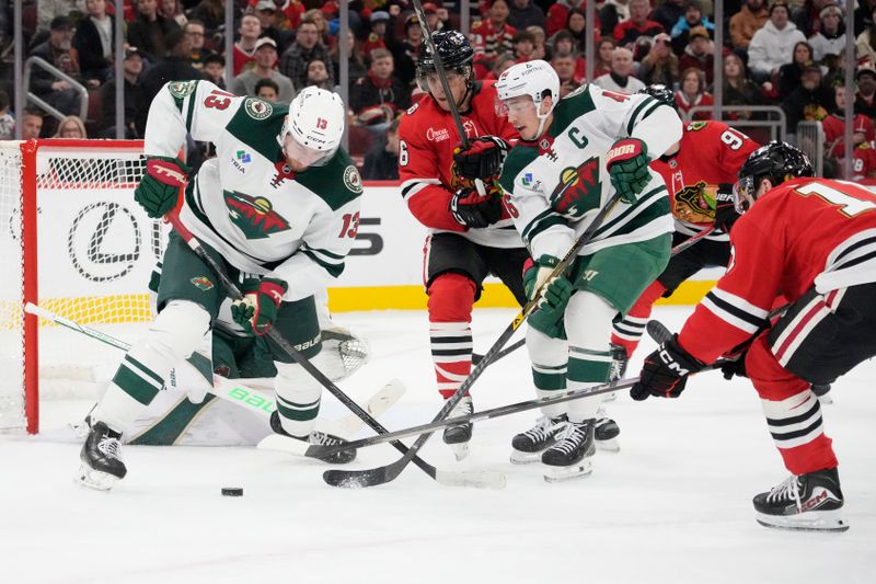 Nov 26, 2025; Chicago, Illinois, USA; Minnesota Wild center Yakov Trenin (13) tries to clear the puck against the Chicago Blackhawks during the second period at United Center. Mandatory Credit: David Banks-Imagn Images