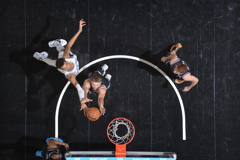 SAN ANTONIO, TX - NOVEMBER 11:   Victor Wembanyama #1 of the San Antonio Spurs and Domantas Sabonis #11 of the Sacramento Kings goes for rebound during a regular season game on November 11, 2024 at the Frost Bank Center in San Antonio, Texas. NOTE TO USER: User expressly acknowledges and agrees that, by downloading and or using this photograph, user is consenting to the terms and conditions of the Getty Images License Agreement. Mandatory Copyright Notice: Copyright 2024 NBAE (Photos by Michael Gonzales/NBAE via Getty Images)