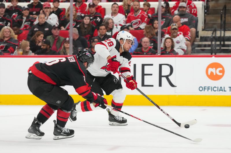 Oct 9, 2025; Raleigh, North Carolina, USA; New Jersey Devils right wing Timo Meier (28) gets the shot against Carolina Hurricanes defenseman Sean Walker (26) during the second period at Lenovo Center. Mandatory Credit: James Guillory-Imagn Images