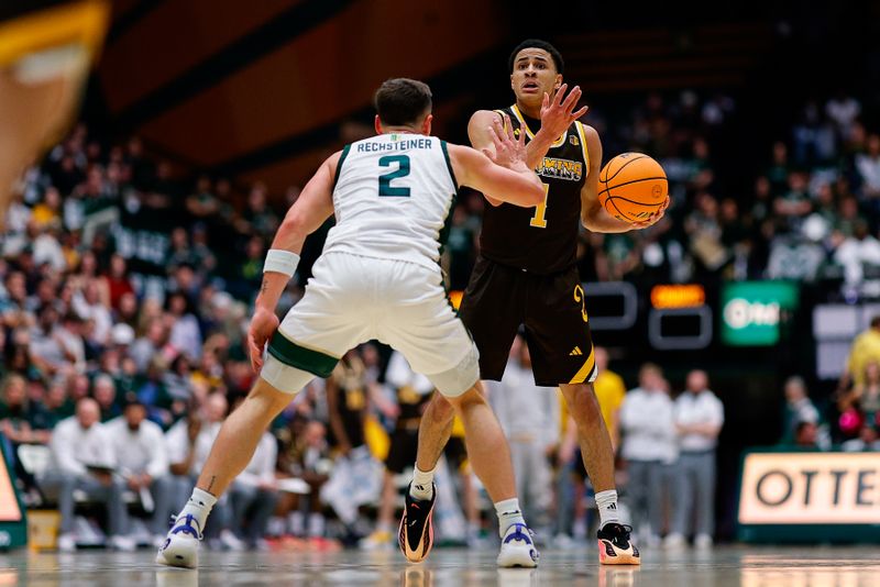 Feb 14, 2026; Fort Collins, Colorado, USA; Wyoming Cowboys guard Damarion Dennis (1) controls the ball as Colorado State Rams guard Brandon Rechsteiner (2) guards in the first half at Moby Arena. Mandatory Credit: Isaiah J. Downing-Imagn Images