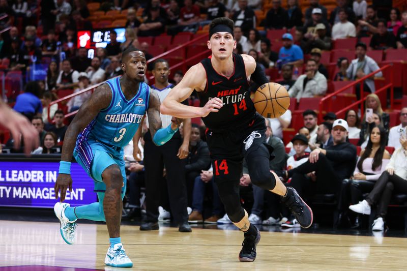 MIAMI, FLORIDA - JANUARY 14: Tyler Herro #14 of the Miami Heat drives against Terry Rozier #3 of the Charlotte Hornets during the first quarter at Kaseya Center on January 14, 2024 in Miami, Florida. NOTE TO USER: User expressly acknowledges and agrees that, by downloading and or using this photograph, User is consenting to the terms and conditions of the Getty Images License Agreement.  (Photo by Megan Briggs/Getty Images)