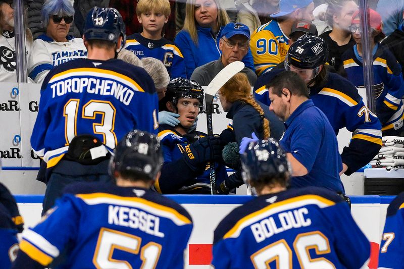 Nov 5, 2024; St. Louis, Missouri, USA;  St. Louis Blues center Dylan Holloway (81) is checked on by a trainer after he came off the ice from a shift against the Tampa Bay Lightning during the first period at Enterprise Center. Dylan Holloway was removed from the bench on a stretcher. Mandatory Credit: Jeff Curry-Imagn Images