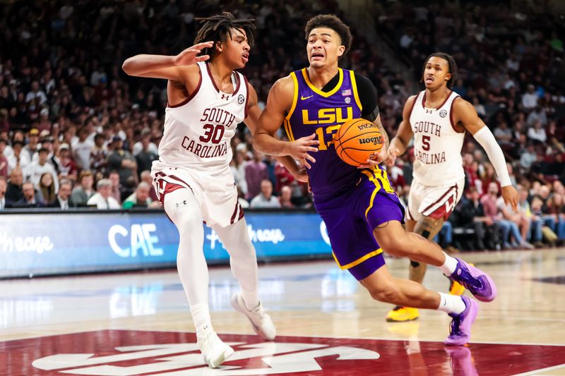 Feb 17, 2024; Columbia, South Carolina, USA; LSU Tigers forward Jalen Reed (13) drives around South Carolina Gamecocks forward Collin Murray-Boyles (30) in the second half at Colonial Life Arena. Mandatory Credit: Jeff Blake-USA TODAY Sports