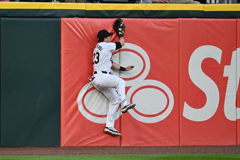 May 28, 2024; Chicago, Illinois, USA;  Chicago White Sox outfielder Andrew Benintendi (23) crashes into the left field wall after making a catch in the first inning against the Toronto Blue Jays at Guaranteed Rate Field. Mandatory Credit: Jamie Sabau-USA TODAY Sports