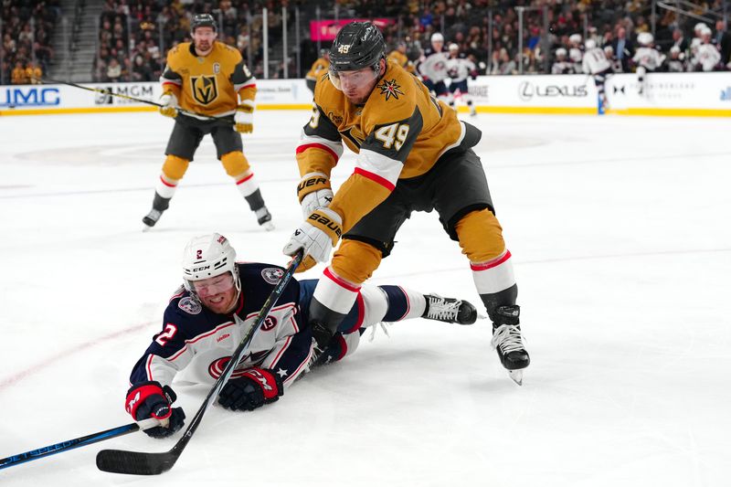 Jan 30, 2025; Las Vegas, Nevada, USA; Columbus Blue Jackets defenseman Jake Christiansen (2) falls to the ice as Vegas Golden Knights center Ivan Barbashev (49) pursues the puck during the second period at T-Mobile Arena. Mandatory Credit: Stephen R. Sylvanie-Imagn Images