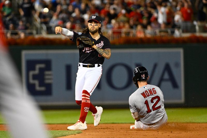 Aug 16, 2023; Washington, District of Columbia, USA; Washington Nationals second baseman Michael Chavis (6) completes a double play over Boston Red Sox catcher Connor Wong (12) to end the sixth inning at Nationals Park. Mandatory Credit: Brad Mills-USA TODAY Sports