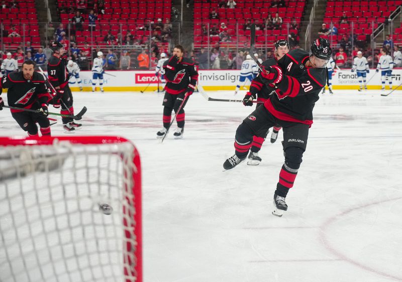 Oct 11, 2024; Raleigh, North Carolina, USA;  Carolina Hurricanes center Sebastian Aho (20) takes a shot during the warmups before the game against the Tampa Bay Lightning at PNC Arena. Mandatory Credit: James Guillory-Imagn Images