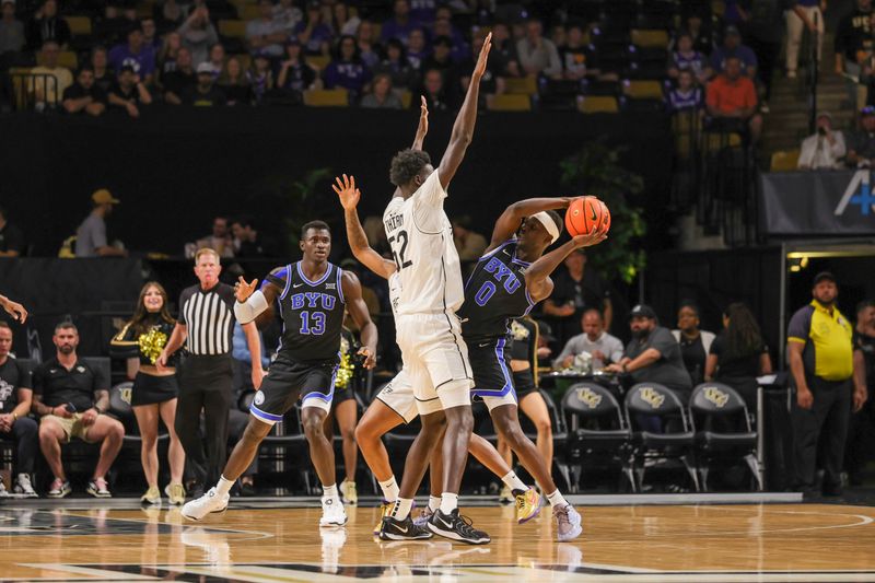 Feb 1, 2025; Orlando, Florida, USA; UCF Knights center Moustapha Thiam (52) defends Brigham Young Cougars forward Mawot Mag (0) during the first half at Addition Financial Arena. Mandatory Credit: Mike Watters-Imagn Images