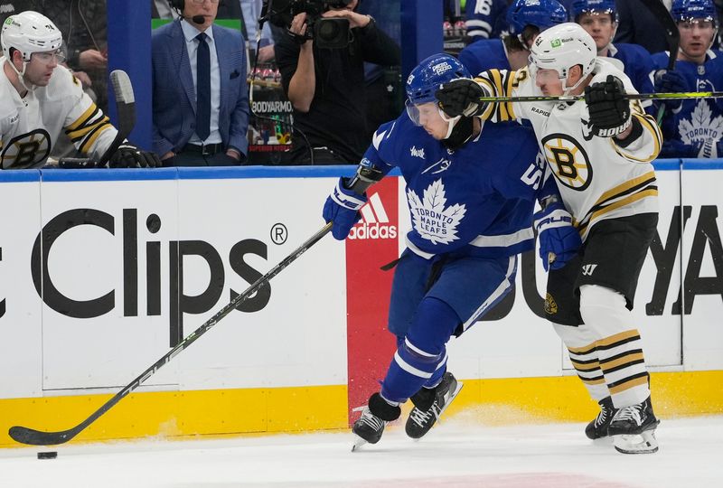 Apr 24, 2024; Toronto, Ontario, CAN; Boston Bruins forward Brad Marchand (63) checks Toronto Maple Leafs forward Tyler Bertuzzi (59) during the first period of game three of the first round of the 2024 Stanley Cup Playoffs at Scotiabank Arena. Mandatory Credit: John E. Sokolowski-USA TODAY Sports