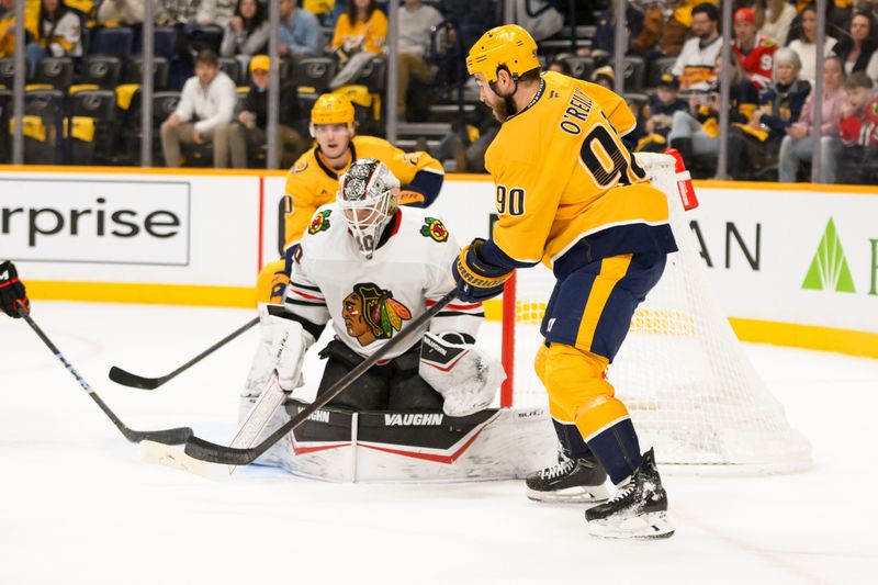 Jan 16, 2025; Nashville, Tennessee, USA;  Chicago Blackhawks goaltender Arvid Soderblom (40) blocks the shot of Nashville Predators center Ryan O'Reilly (90) during the first period at Bridgestone Arena. Mandatory Credit: Steve Roberts-Imagn Images