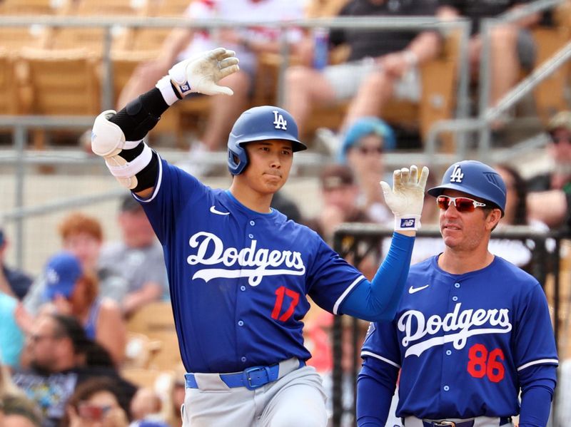 Mar 6, 2024; Phoenix, Arizona, USA; Los Angeles Dodgers designated hitter Shohei Ohtani (17) celebrates alongside first base coach Clayton McCullough against the Chicago White Sox during a spring training baseball game at Camelback Ranch-Glendale. Mandatory Credit: Mark J. Rebilas-USA TODAY Sports